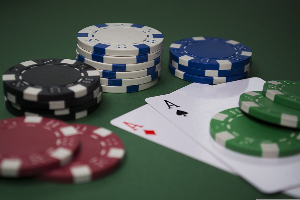 Five different poker chips around two aces.