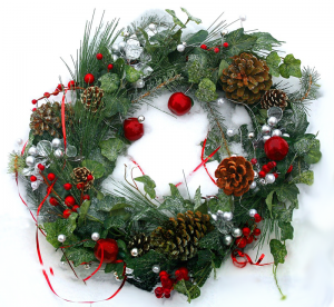 Green wreath with red bulbs and ribbon. Touches of pine cones and white berries.