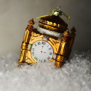 Gold clock sitting in a bed of snow.