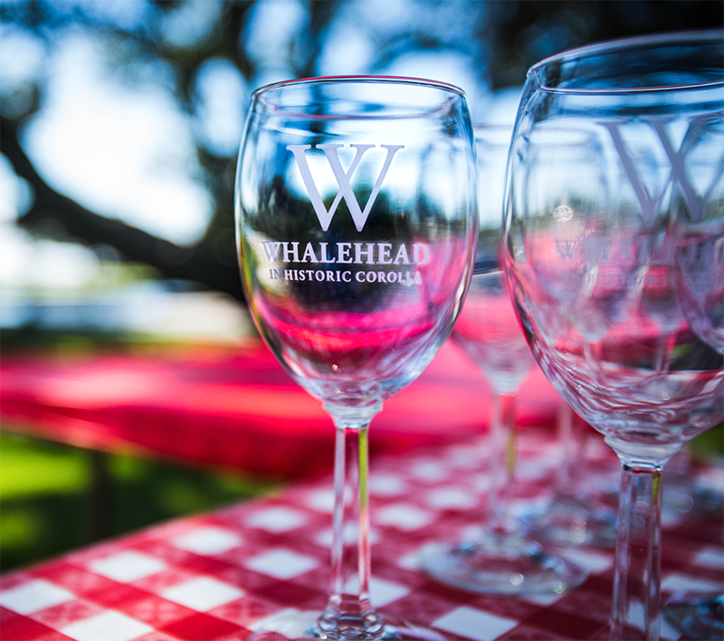 Whalehead in Historic Corolla wine glasses with a blurred background.