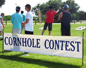 Cornhole Contest banner with players in the background.