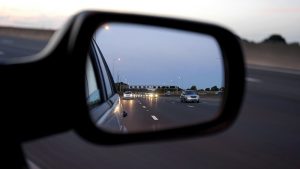 Traffic showing in a car side mirror.