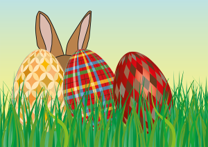 Three colored eggs sitting in the grass with rabbit ears poking over top.