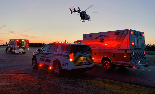 At sunset showing a ambulance, truck and helicopter.
