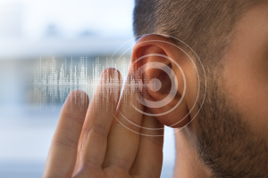 Hand held up to an ear with sound waves coming out.