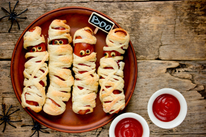 Hot Dogs created to look like mummies. They are wrapped with dough and eyes are placed on the hot dog.