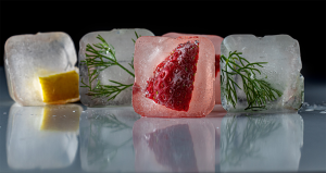 Ice cubes with strawberry, mint and lemon frozen inide.