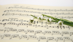 Sheet of music with flowers on top of the sheet.