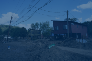 Houses damaged by flood, just debris and mud.