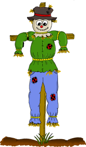 Hanging Scarecrow. Green top and blue pants on a wooden stand.