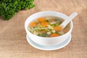 A bowl of vegetable soup on a cloth.