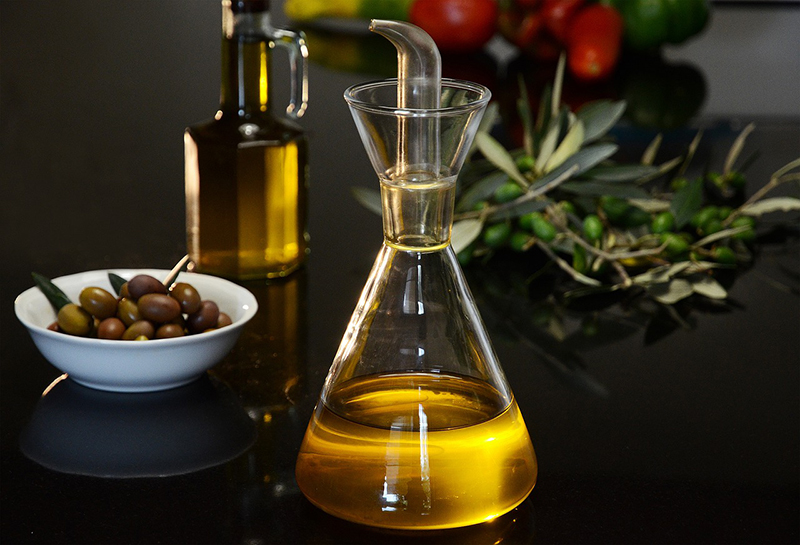 Decorative Oil decanter, bowl of olives and bottle of oil.
